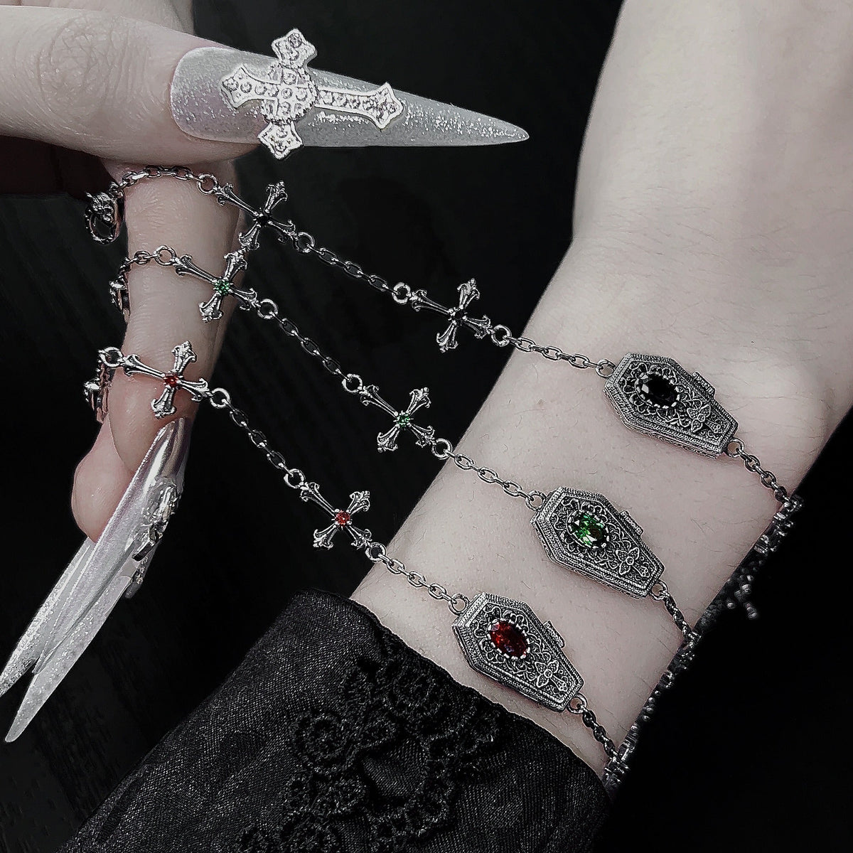 Red, green, and black sterling silver gothic coffin cross bracelets worn on the wrist
