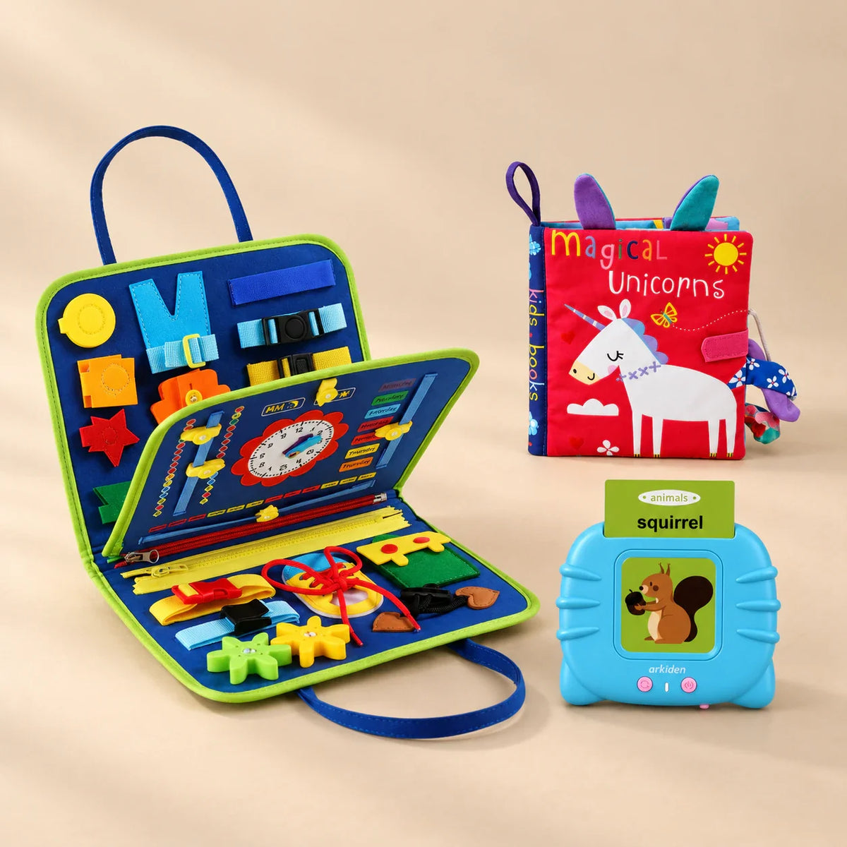 Grandparent Gift Bundle with a dinosaur blue busy board, blue talking flashcard reader and Magical Unicorns sensory book on a beige studio surface.
